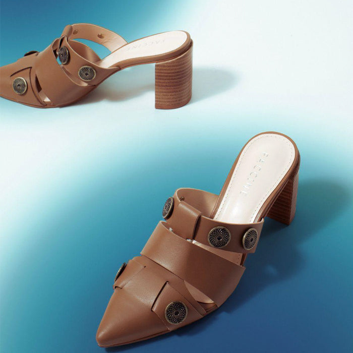 Stylish brown heeled mules with cut-out straps and metal stud accents, set against a gradient blue background.