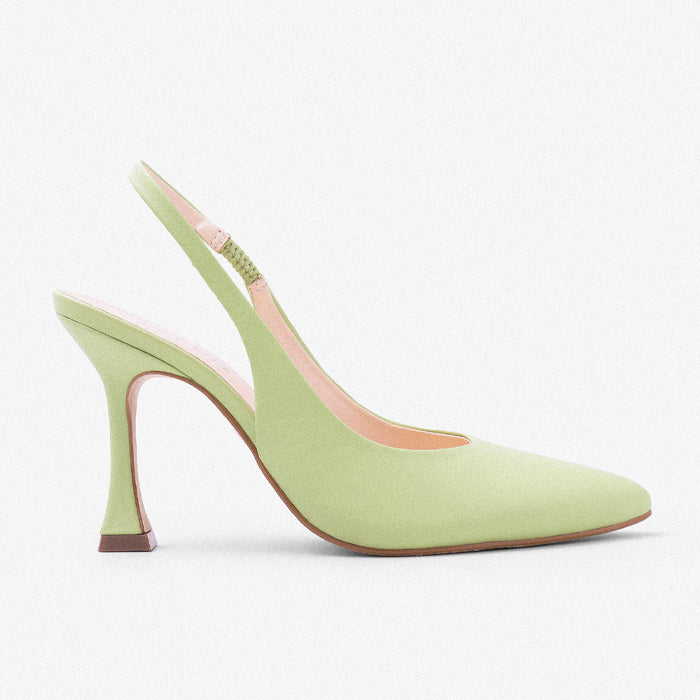 A stylish green slingback heel with a pointed toe and a slim, elegant heel, set against a ky blue background