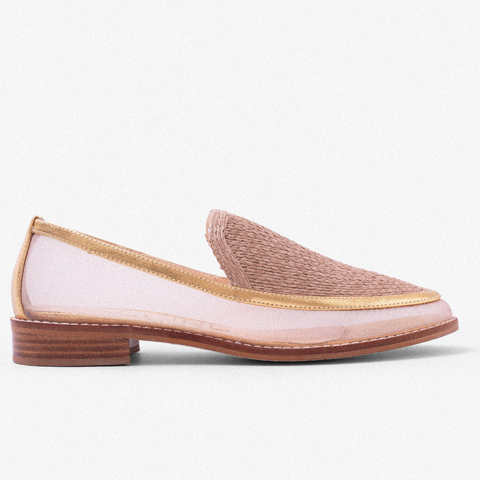 A stylish light pink slip-on shoe with a woven upper, mesh side panels, and a wooden heel, displayed against a neutral background.